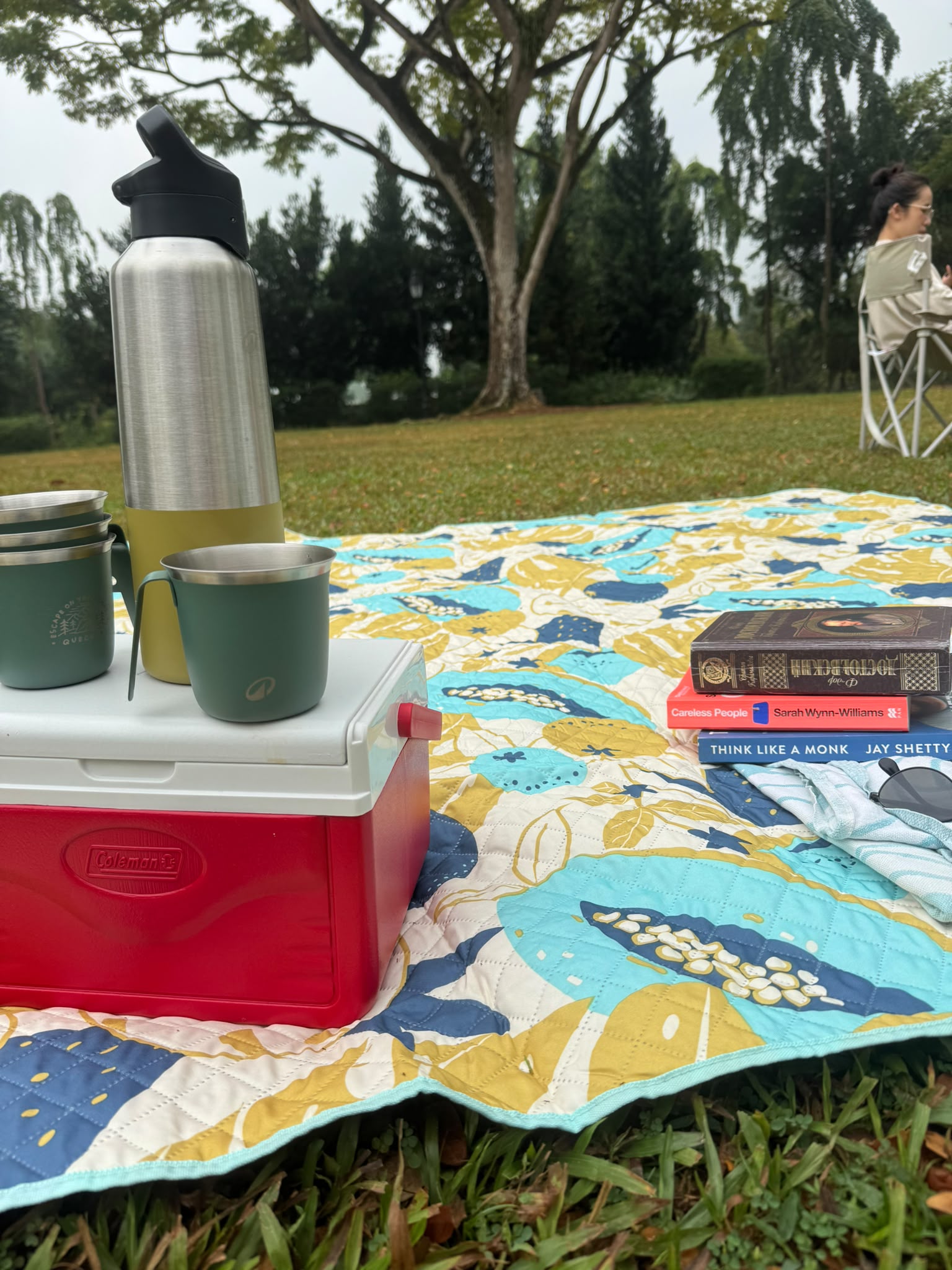 Coffee flasks, picnic blanket and a small stack of books